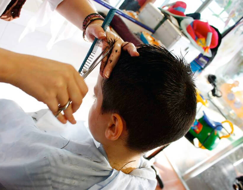 Peluquera cortando el pelo a un niño